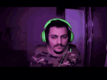 a man wearing green headphones and a camouflage shirt is smiling .
