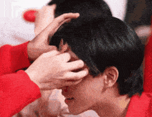 a person in a red shirt is holding a person 's hair