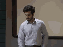 a man in a blue shirt stands in front of a white board