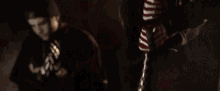 a woman is holding a bat in a dark room while another woman looks on .