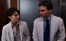 a man and a woman in lab coats are talking