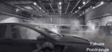 a man is driving a car in a garage with the words yakuza pozdravuje on the bottom right