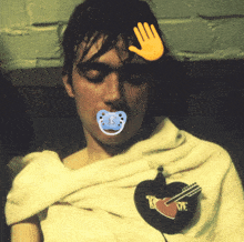 a man with a pacifier in his mouth and a guitar pin on his shirt
