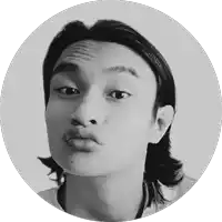 a black and white photo of a young man with long hair making a funny face