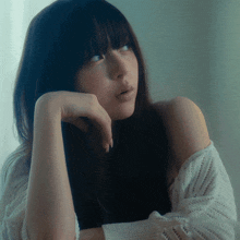 a close up of a woman 's face with a white sweater on