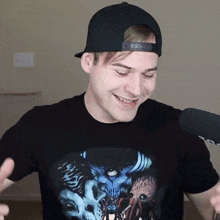 a man wearing a hat and a black t-shirt with a monster on it