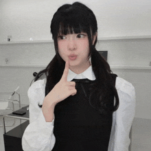 a girl with pigtails is making a funny face with her finger to her lips