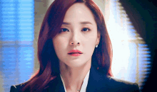 a woman with red hair is wearing a black suit and a white shirt