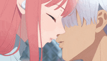 a man and a woman kissing in front of a fence