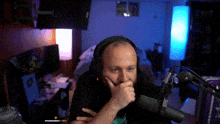 a man wearing headphones is sitting in front of a microphone in a room