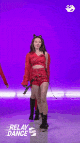 a group of young women are dancing on a stage in red outfits .