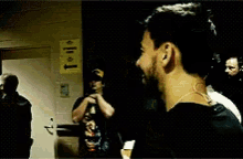 a man in a black shirt with a skull on it stands in front of a door