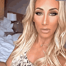 a woman with a nose ring is taking a selfie in a bedroom