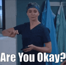 a woman in scrubs is holding a cell phone and asking are you okay