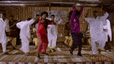 a group of people are dancing in front of a man laga sign