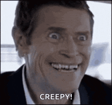 a man is smiling and making a creepy face while sitting in a car .