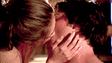 a close up of a woman kissing a man 's face