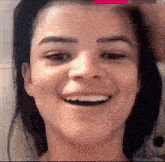 a close up of a woman 's face smiling with a man 's hand on her head .
