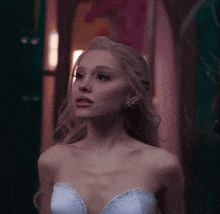 a woman with blonde hair is wearing a strapless dress with rhinestones
