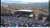 a large crowd of people are gathered in front of a stage