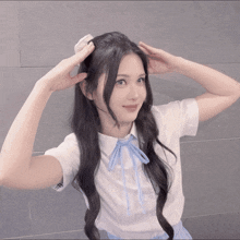 a girl with long black hair is wearing a white shirt with a blue bow