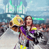a woman in a wrestling outfit is holding a championship belt