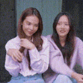 two women are sitting next to each other on a porch .