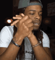 a man with dreadlocks is wearing a shirt that says aco on it