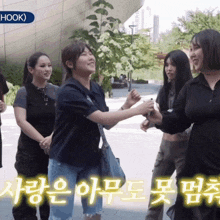 a group of women are standing in front of a building that says hook on it