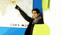 a man stands in front of a map that says " jake 's map "