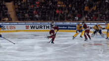 a hockey game is being played in front of a wurth ad