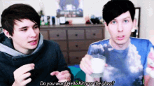 two young men are sitting next to each other and one of them is holding a glass and asking the other if he wants hello kitty