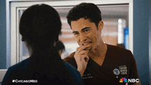 a man in a chicago medical center scrub is biting a cookie