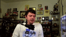 a man stands in front of a microphone wearing a white shirt with a dragon ball z graphic on it