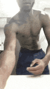 a shirtless man is taking a selfie in front of a mirror in a bathroom .