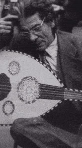 a black and white photo of a man playing a guitar with the letters bbc on the bottom