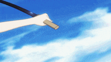 a person holding a sword against a blue sky with white clouds