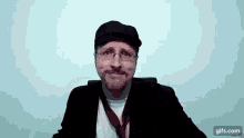 a man with a beard and glasses is wearing a hat and a tie .