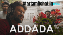 a man wearing headphones looks at some flowers with the words addada written below him