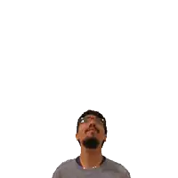 a man with glasses and a beard is looking up at a green cross on his head