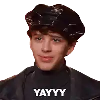a young man wearing a police hat and a turtleneck has the word yayy on his shirt