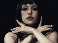a close up of a woman 's face with her hands folded
