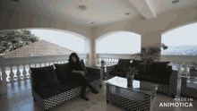 a woman sits on a black and white couch in a room made in animotica