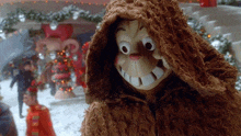 a stuffed animal wearing a hooded jacket with a big smile on his face .