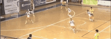 a soccer game is being played on a court with a sign that says asegroup in the background