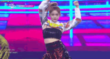 a woman is dancing on a stage in front of a crowd .