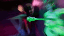 a blurry picture of a person holding a green object in a dark room