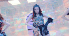 a group of girls are dancing in a room with blue lights