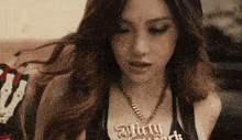 a woman wearing a necklace that says dirty