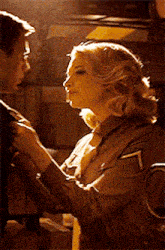 a man and a woman are standing next to each other and the woman is touching the man 's arm